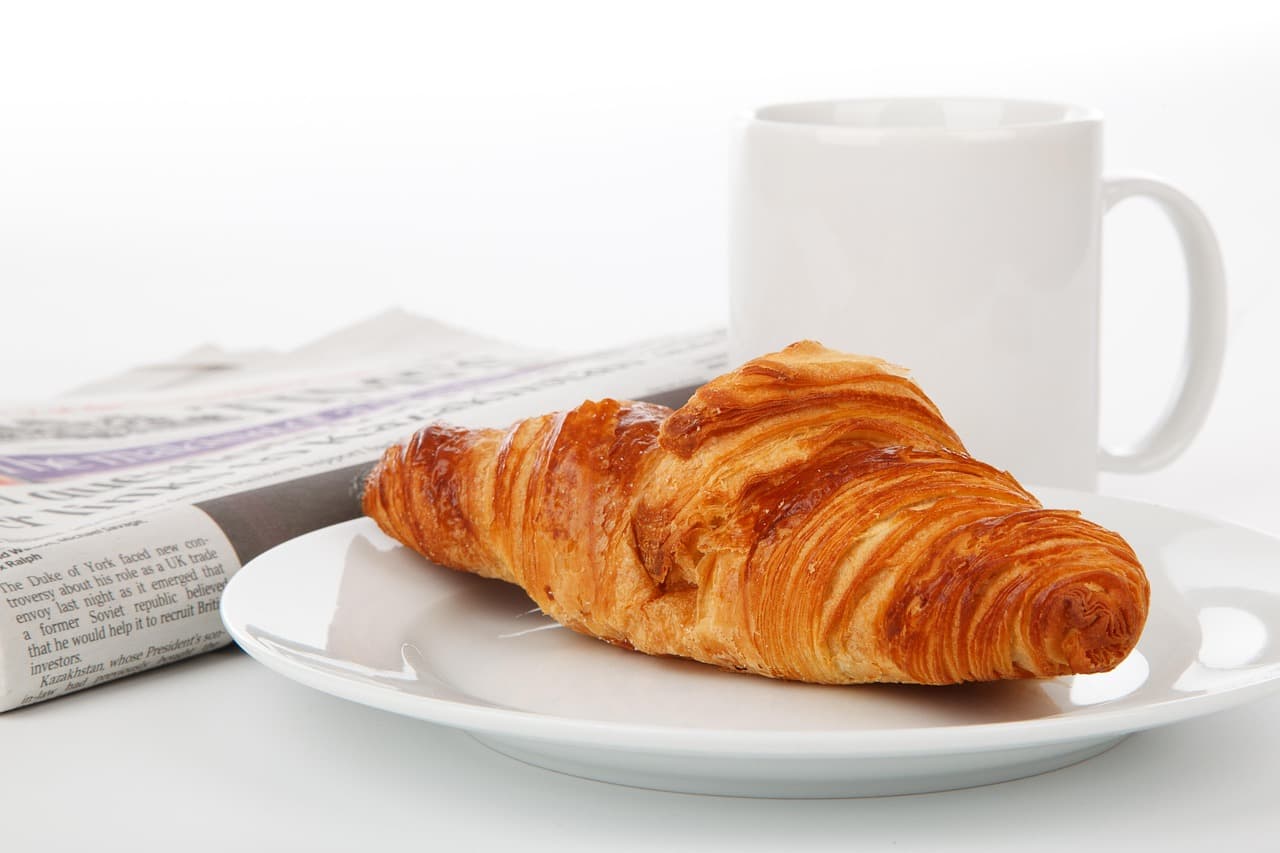 A croissant and a mug of coffee at breakfast